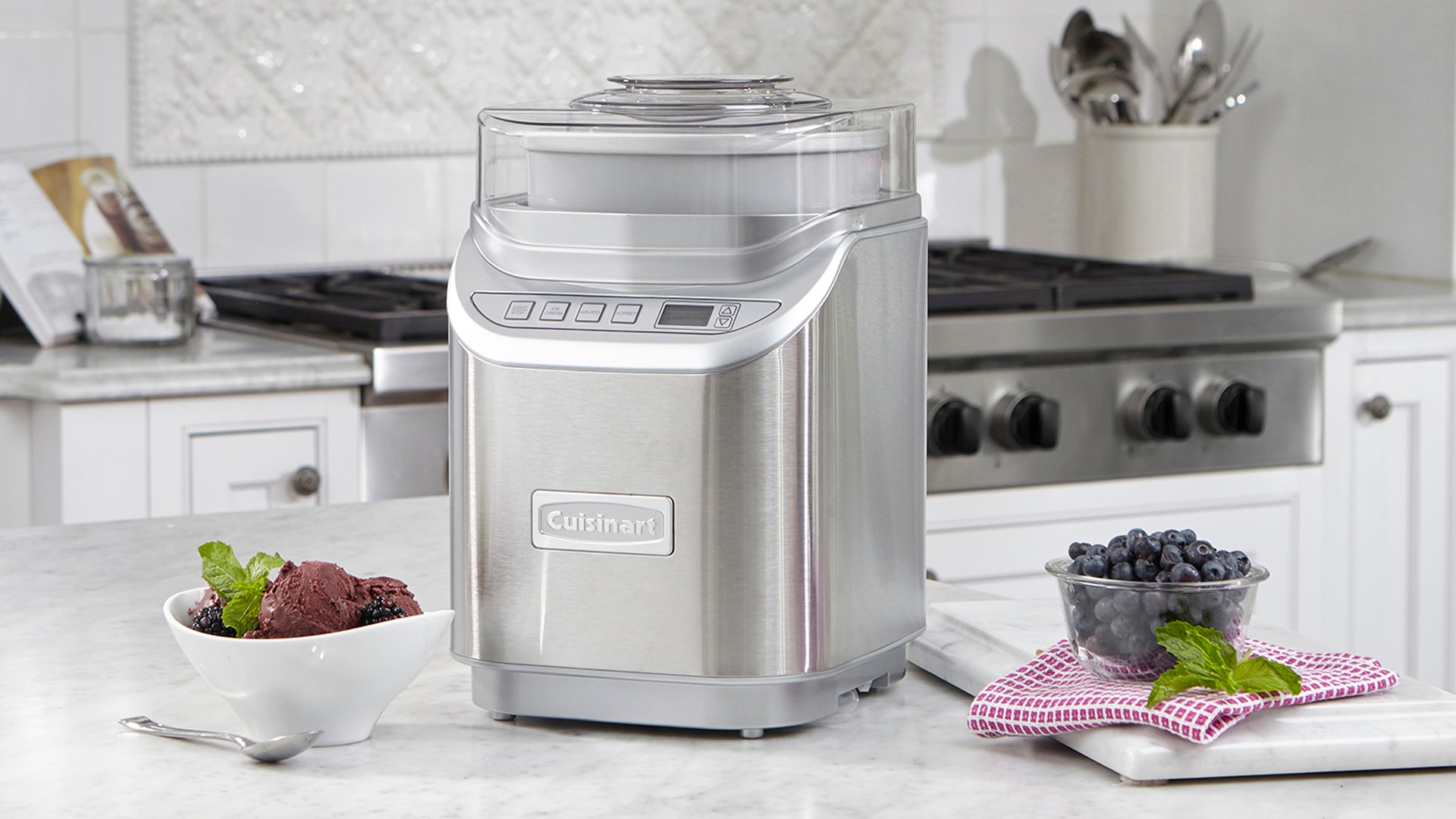 An ice cream maker along with some berries in the kitchen